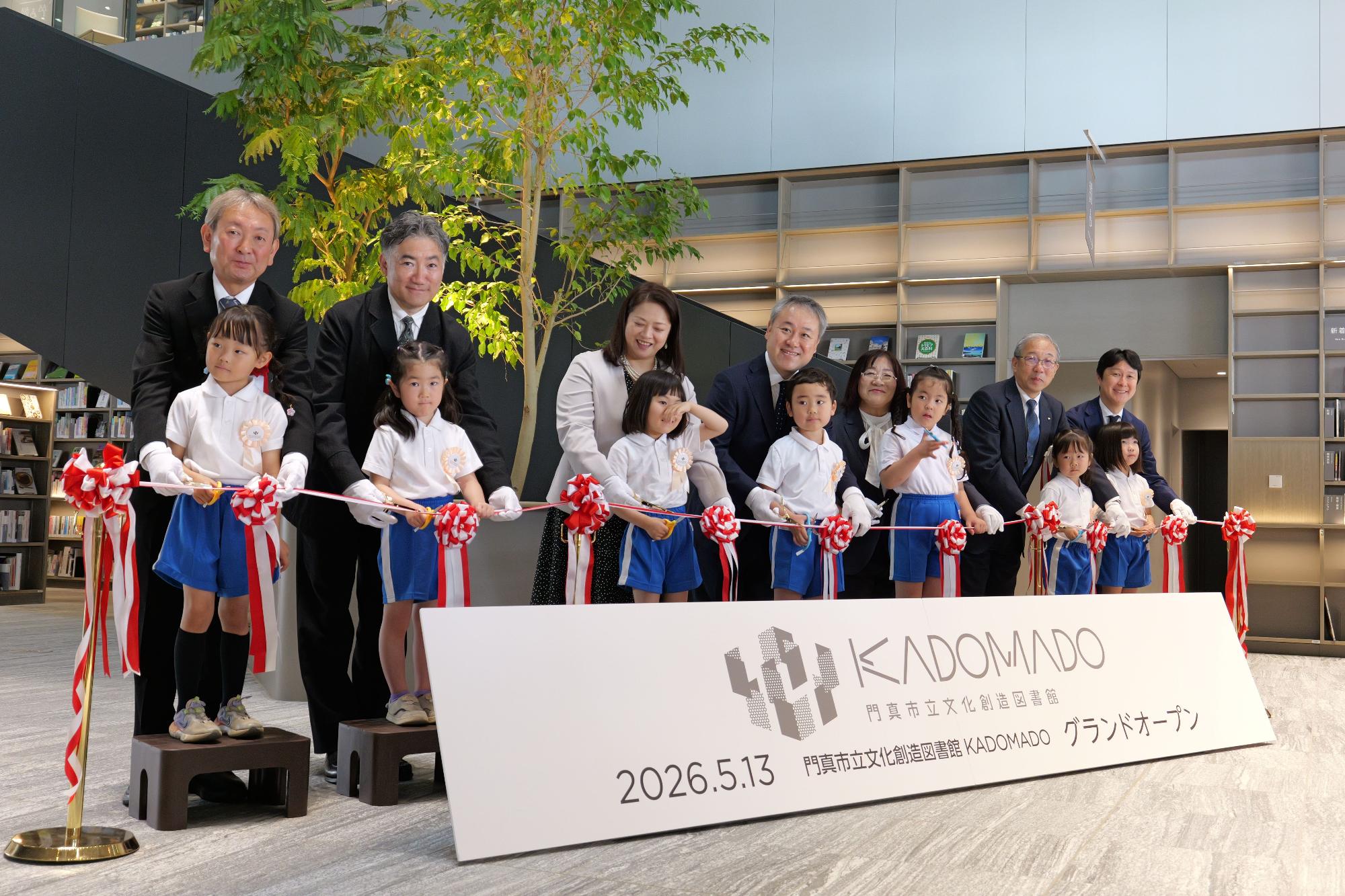 KADOMADOグランドオープンで子供たちとテープカットをする写真です
