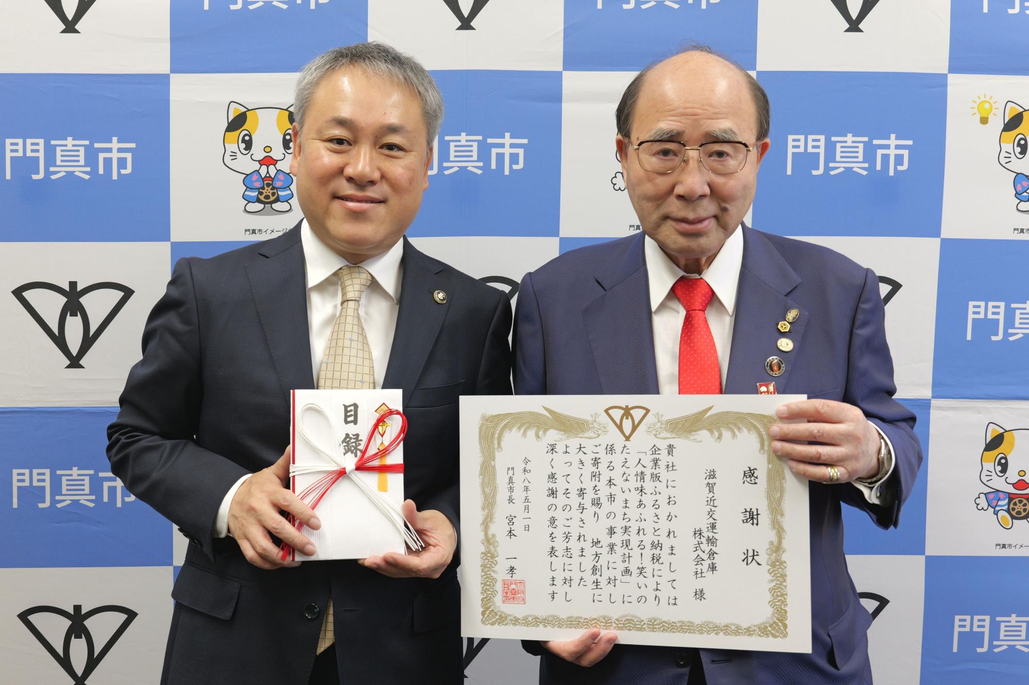 滋賀近交運輸倉庫株式会社様に感謝状をお渡しして一緒に並んでいる写真です
