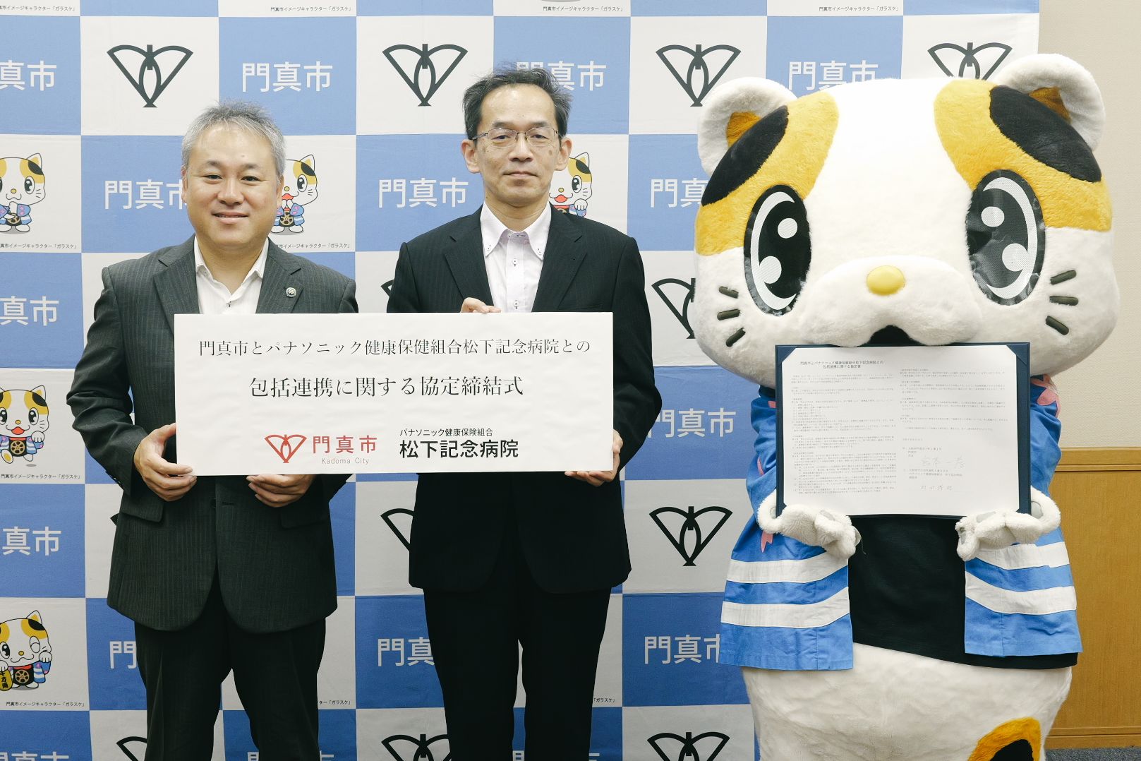 松下記念病院の方と市長とガラスケが並んで写っている写真です