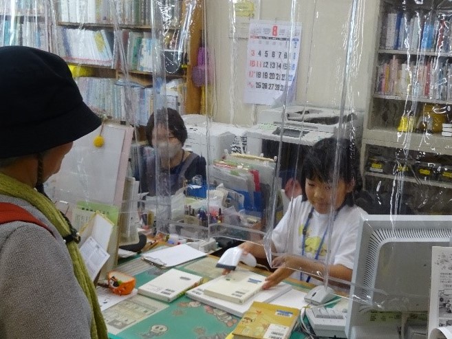 一日図書館員が図書館のカウンター業務を体験している様子