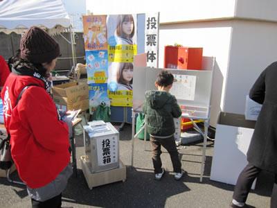 記載台で投票用紙に記入している子供の写真