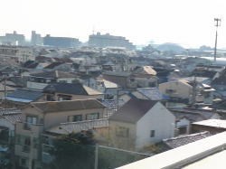 屋上より東を臨む。住宅地の向こう、右手に「なみはやドーム」が見えます。